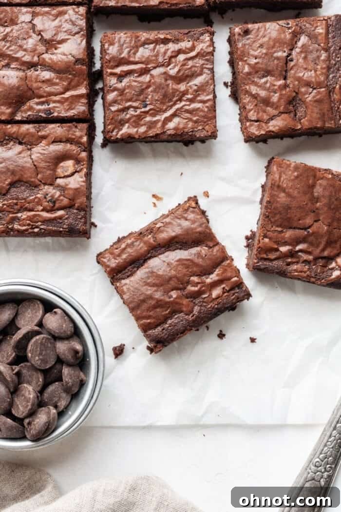 Decadent cassava flour brownies arranged neatly on white parchment paper