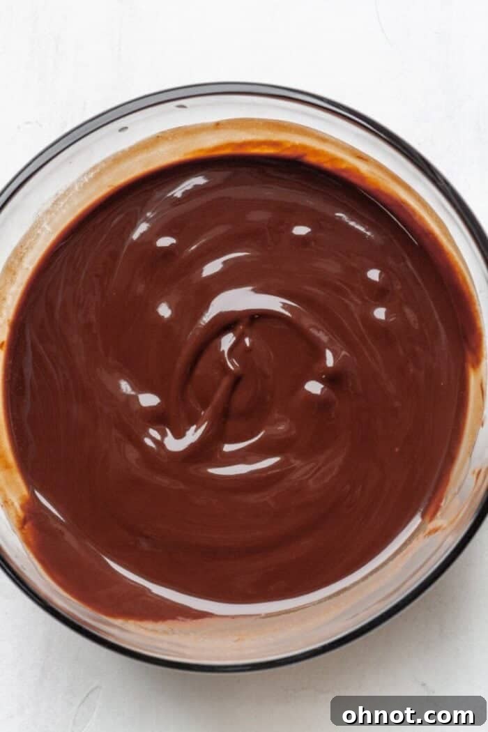 A bowl filled with rich, glossy melted dark chocolate and butter