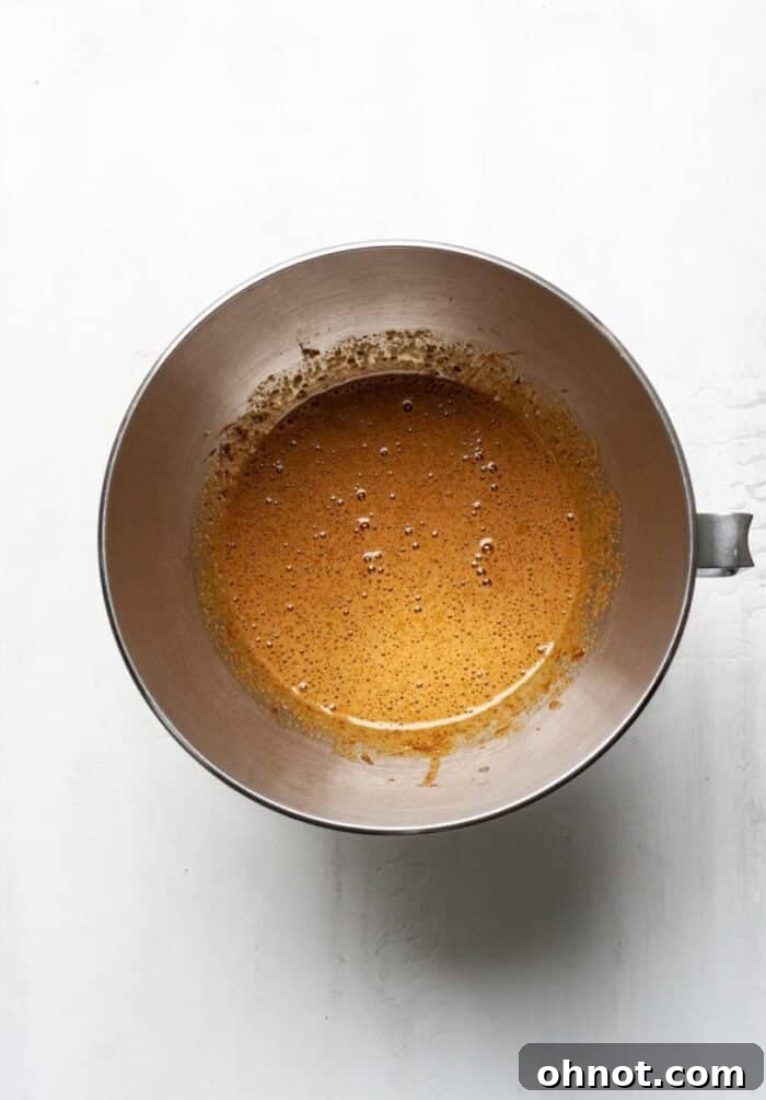 Fluffy eggs and golden coconut sugar mixing in a stand mixer