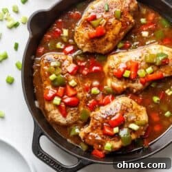 Cajun smothered pork chops in a cast iron skillet