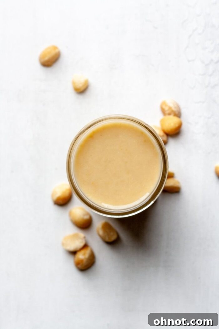 A glass Mason jar filled with homemade macadamia nut butter, ready for storage.