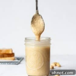 Homemade macadamia nut butter in a blender, ready to be poured into a jar.