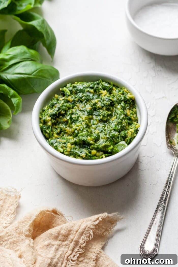 AIP Whole30 pesto with spoon and basil leaves