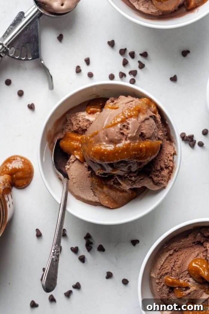 Rich peanut butter caramel sauce drizzled generously over a scoop of creamy chocolate ice cream, highlighting its delightful texture.