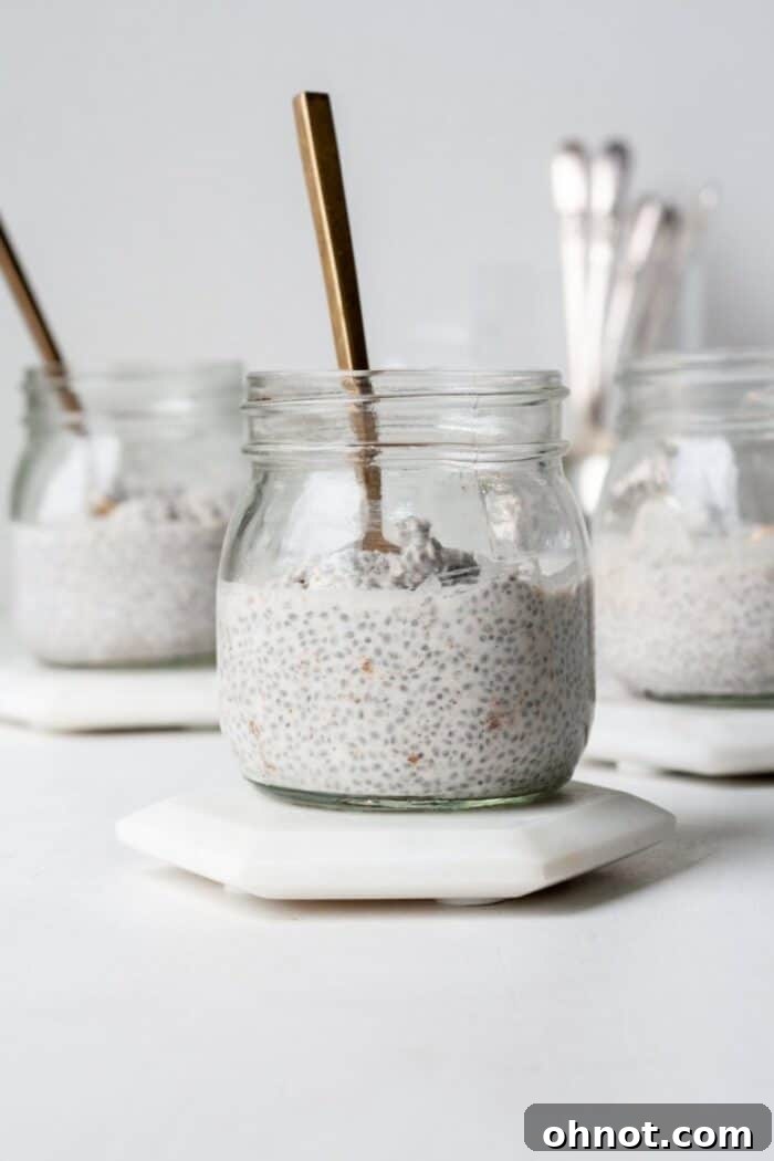 Whole30 chia pudding in glass jars, topped with fresh berries and coconut flakes.