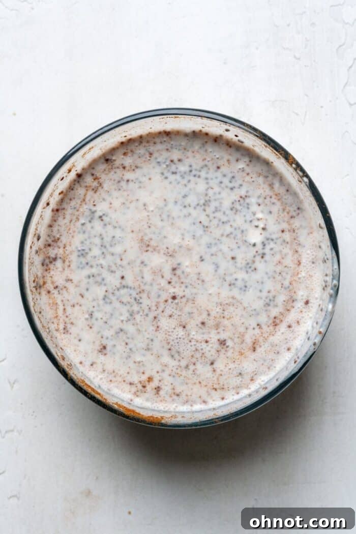 Paleo chia pudding ingredients being mixed in a glass bowl.