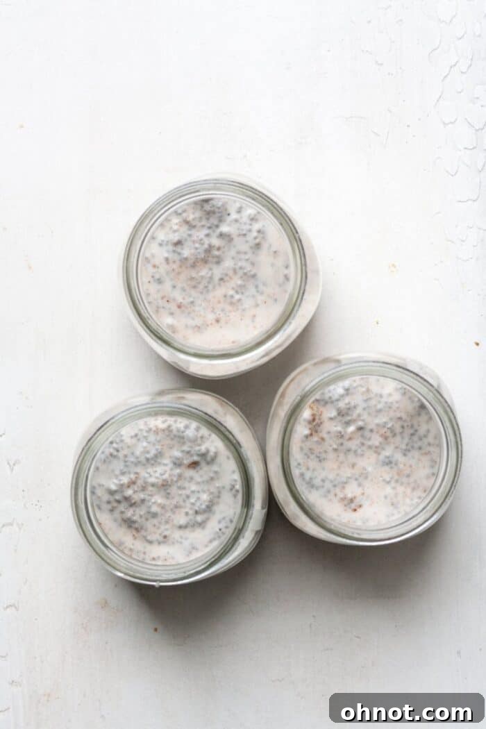 Chia pudding mixture poured into three glass jars ready for refrigeration.
