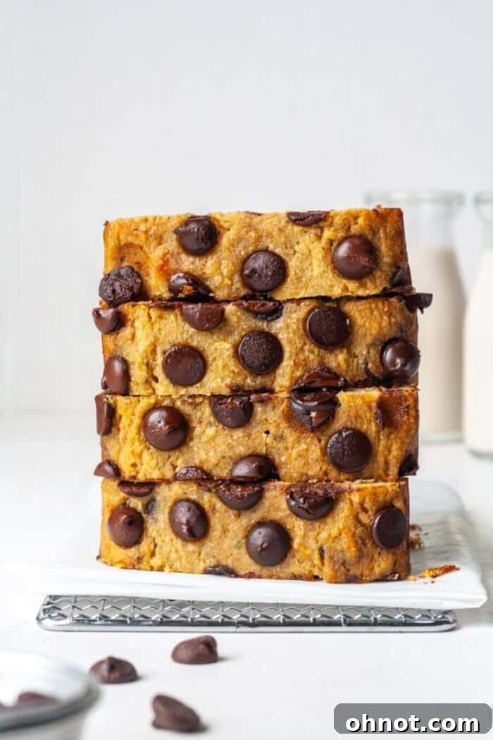 A whole loaf of gluten-free zucchini banana bread with chocolate chips, presented on a pristine white backdrop.