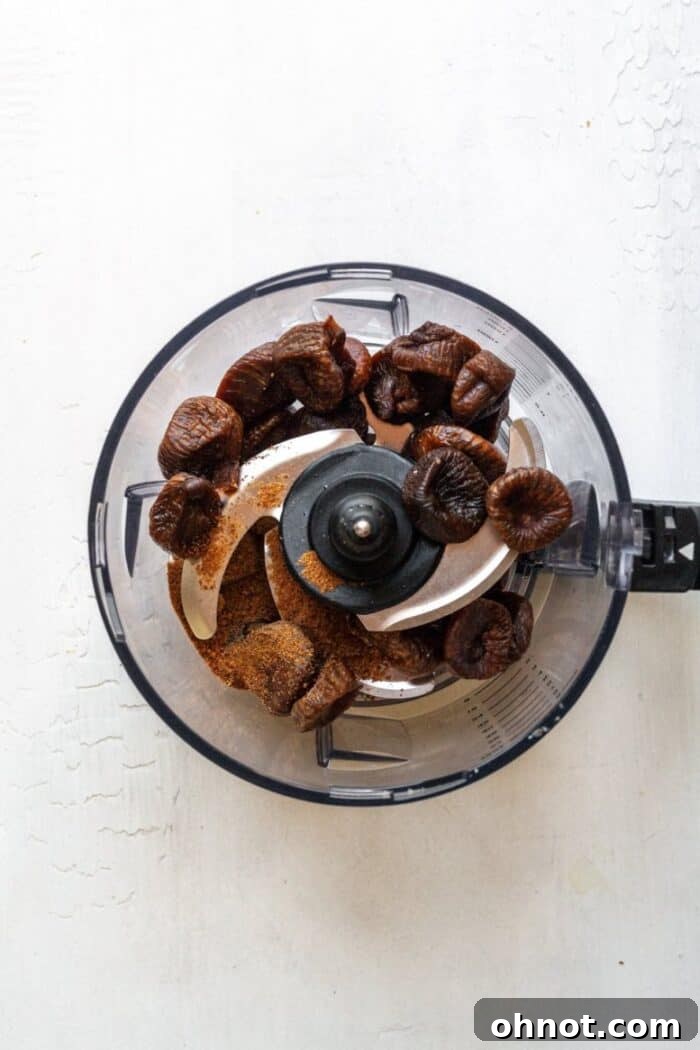 Dried figs and other filling ingredients being added to a blender to create the fig paste.