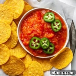 Mango habanero salsa in a white bowl with tortilla chips