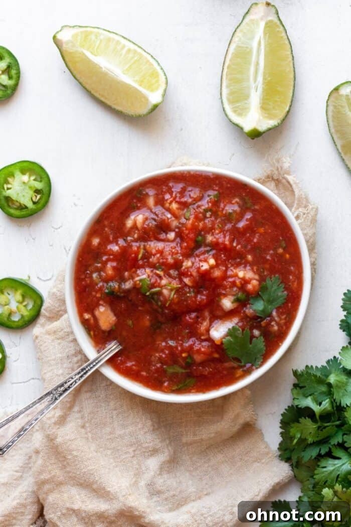 Salsa in a white bowl with a slice of lime