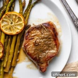 Pork chop and asparagus on white plate, thumbnail image