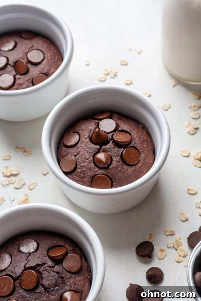 Close-up of three ramekins filled with warm chocolate baked oatmeal, garnished with chocolate chips