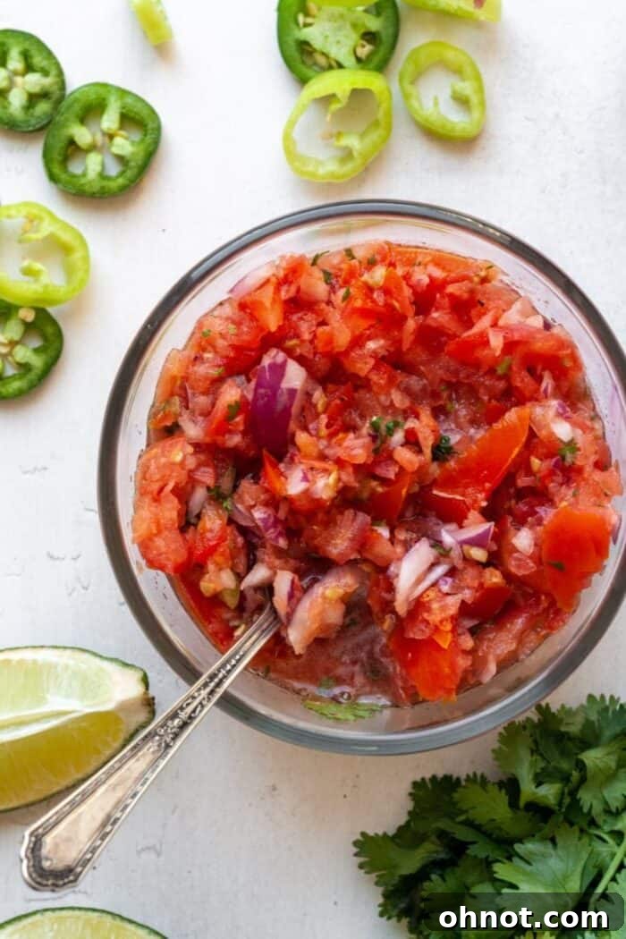 A pristine glass bowl filled with rich, textured homemade salsa, garnished with fresh herbs, sitting on a clean surface, ready to be served or enjoyed as a healthy snack.