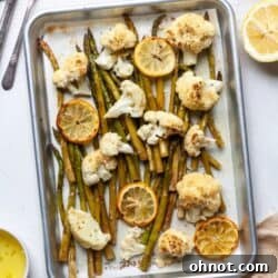 Roasted cauliflower and asparagus with lemon on baking pan