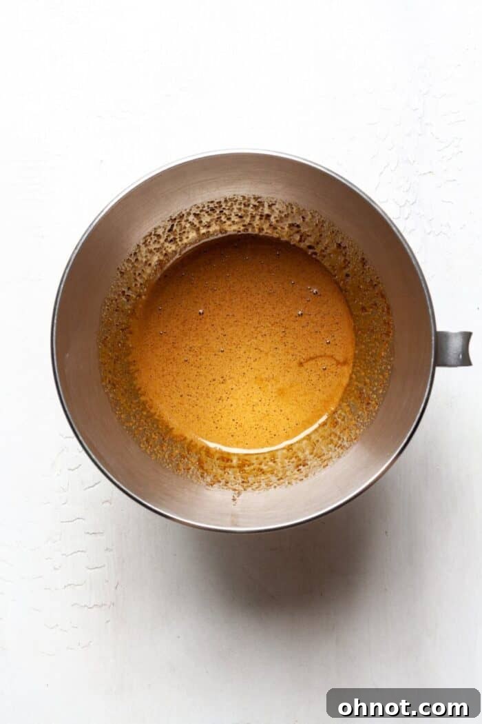 Eggs and coconut sugar beaten until light and frothy in a mixing bowl, creating the base for the brownie batter