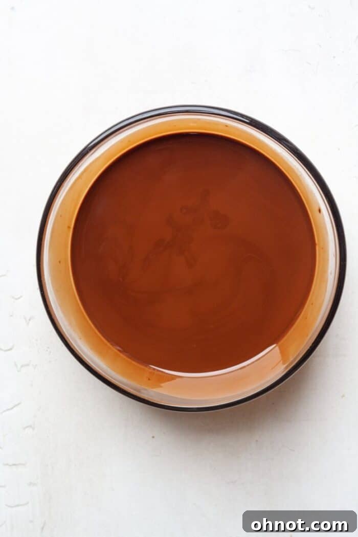 Close-up of melted dark chocolate in a bowl, highlighting its creamy and luxurious consistency