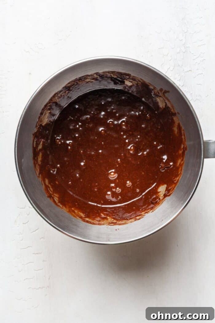Gluten-free brownie batter in a mixer, showcasing the smooth, dark consistency after chocolate is added