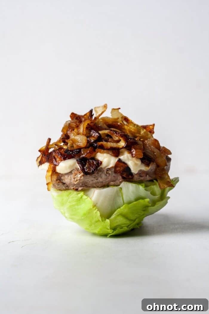 Keto turkey burger with rich caramelized onions and a vibrant lettuce wrap, showcasing a perfectly cooked patty