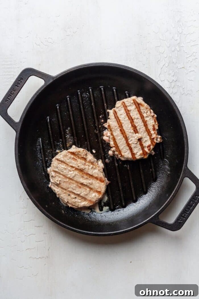Cooked turkey burgers with a golden-brown sear in a cast iron skillet