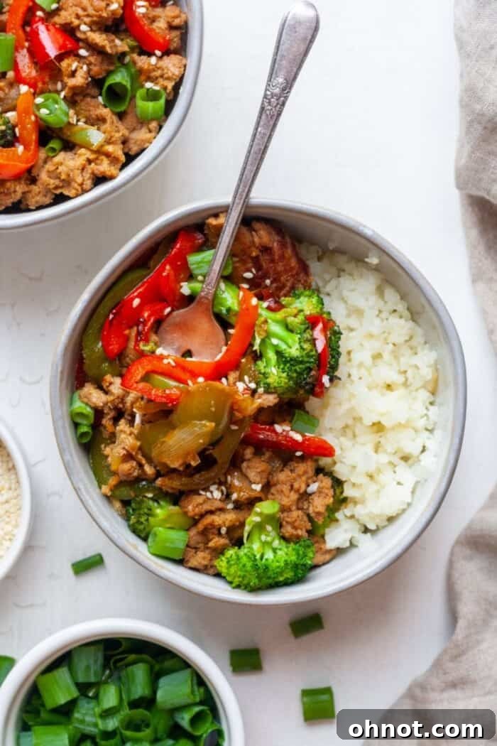 Ground turkey with teriyaki sauce in bowls, garnished with sesame seeds and green onions.