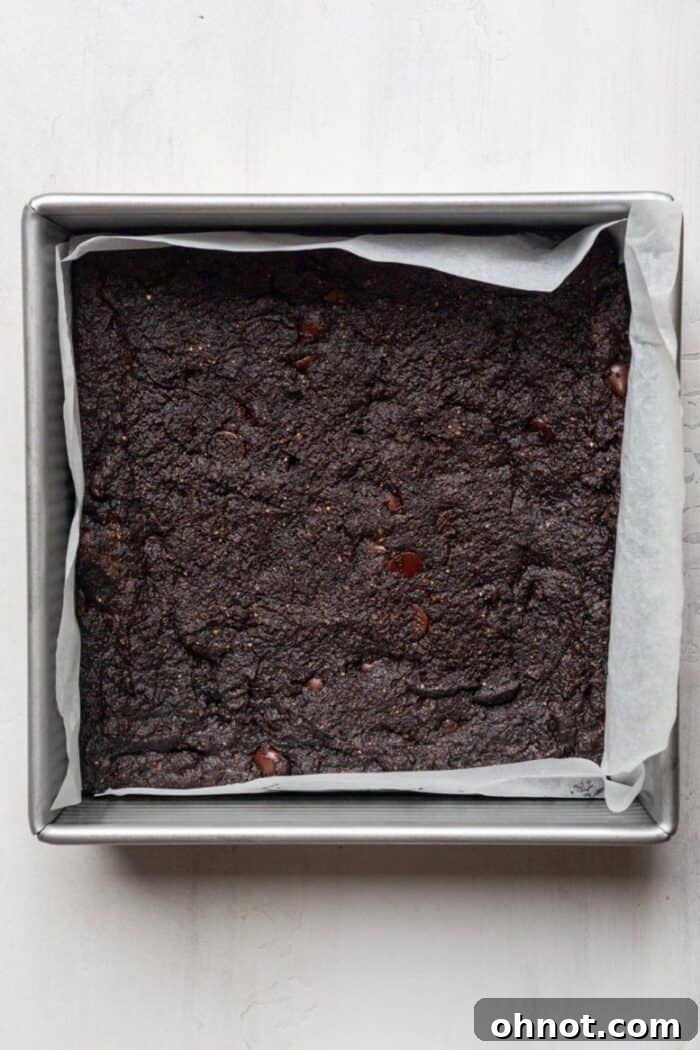 Freshly baked egg-free brownies cooling in the pan, displaying a beautifully set top crust