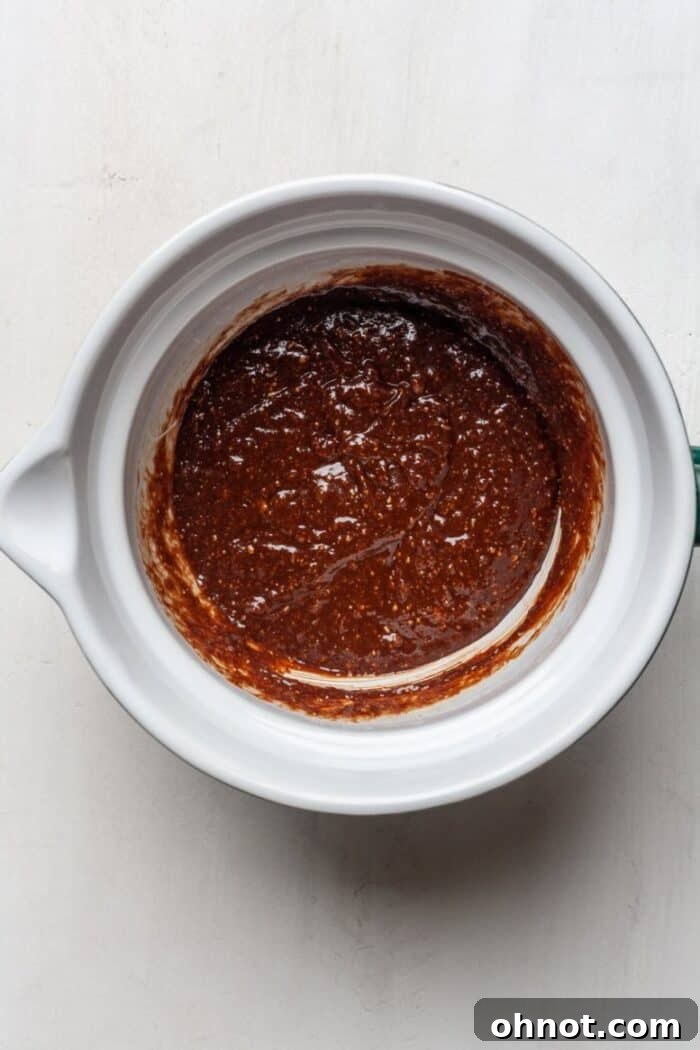 Smooth vegan brownie batter in a mixing bowl, prior to adding dry ingredients