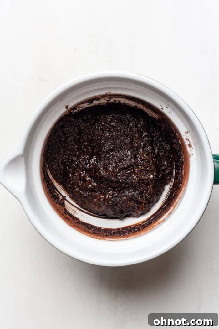 Brownie batter in a bowl, with dry ingredients recently mixed in