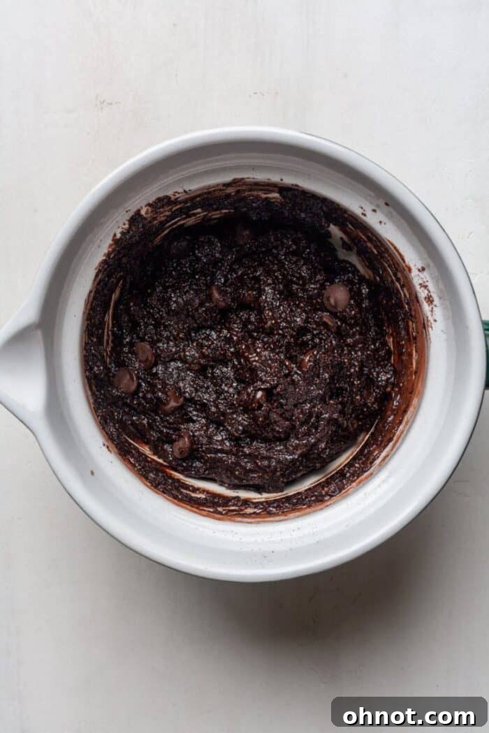Vegan brownie batter featuring generously folded-in chocolate chips