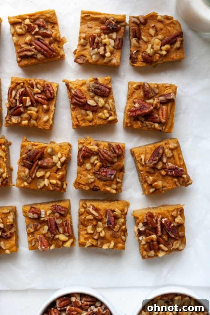 Close-up of a sweet potato blondie bar, highlighting its soft texture and the scattered nuts on top.