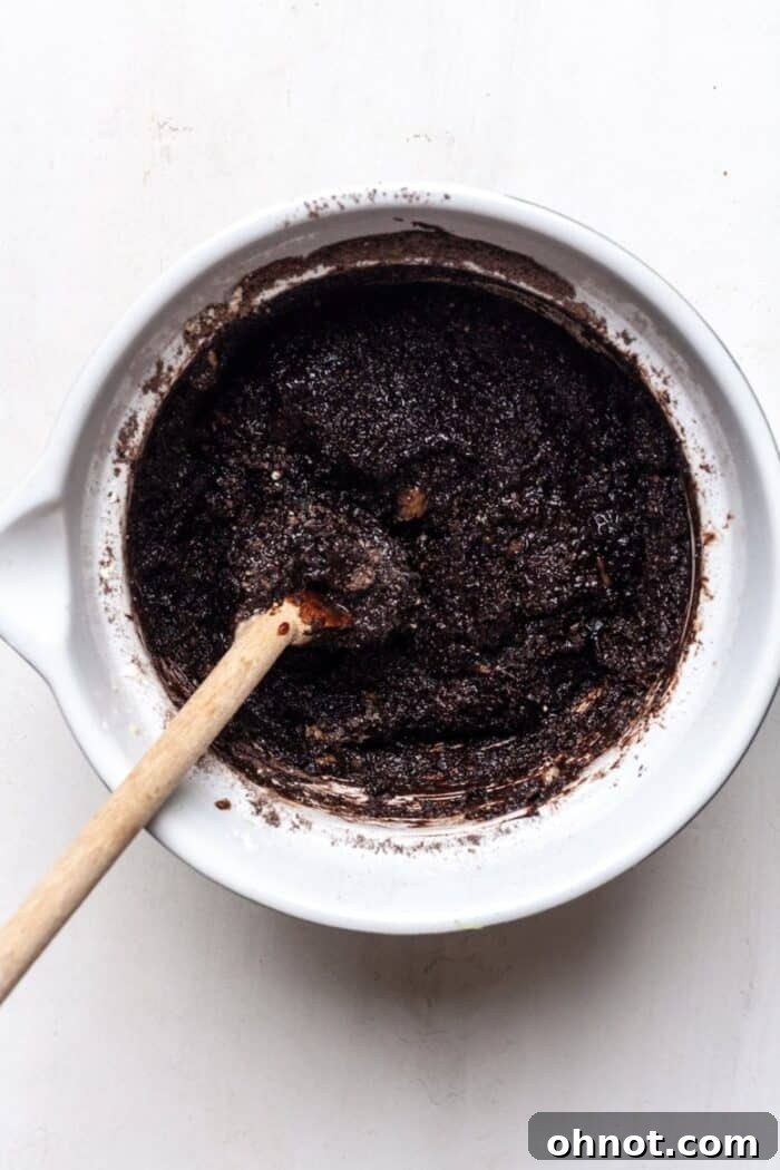 The smooth, dark chocolate muffin batter in a mixing bowl, ready for the final, fresh additions.