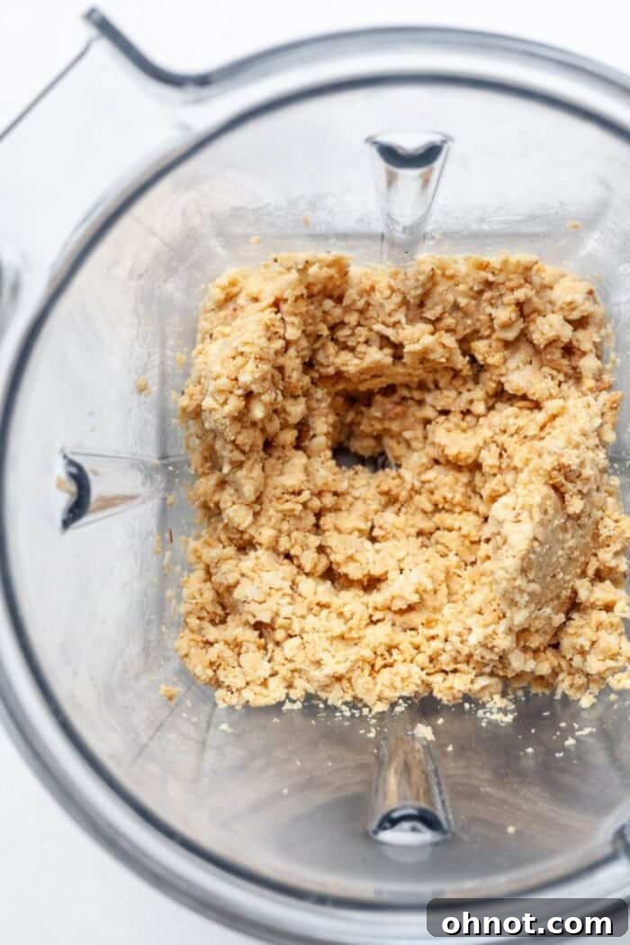 Roasted peanuts forming a thick paste in a blender after about 1 minute of processing.