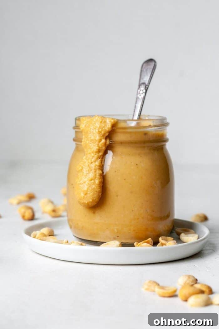 A glass jar filled with freshly made homemade Vitamix peanut butter, topped with a lid.