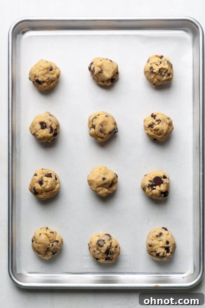 Cookie dough balls neatly arranged on a baking sheet.