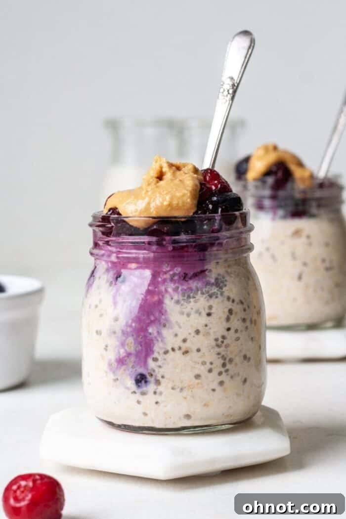Overnight oats in a jar topped with frozen fruit and peanut butter drizzle