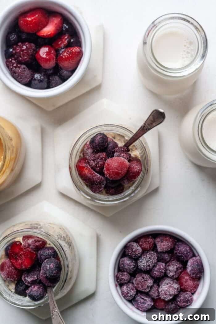 Two glass jars of overnight oats with fruit on top