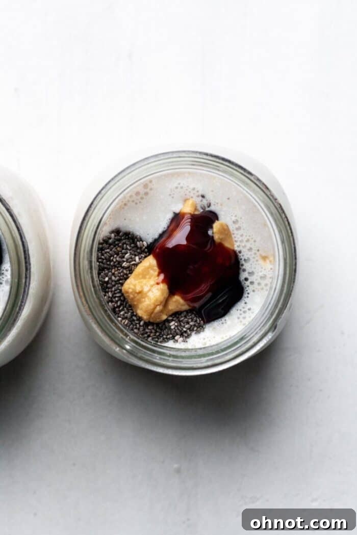 Glass jar with mixed oatmeal ingredients, before chilling