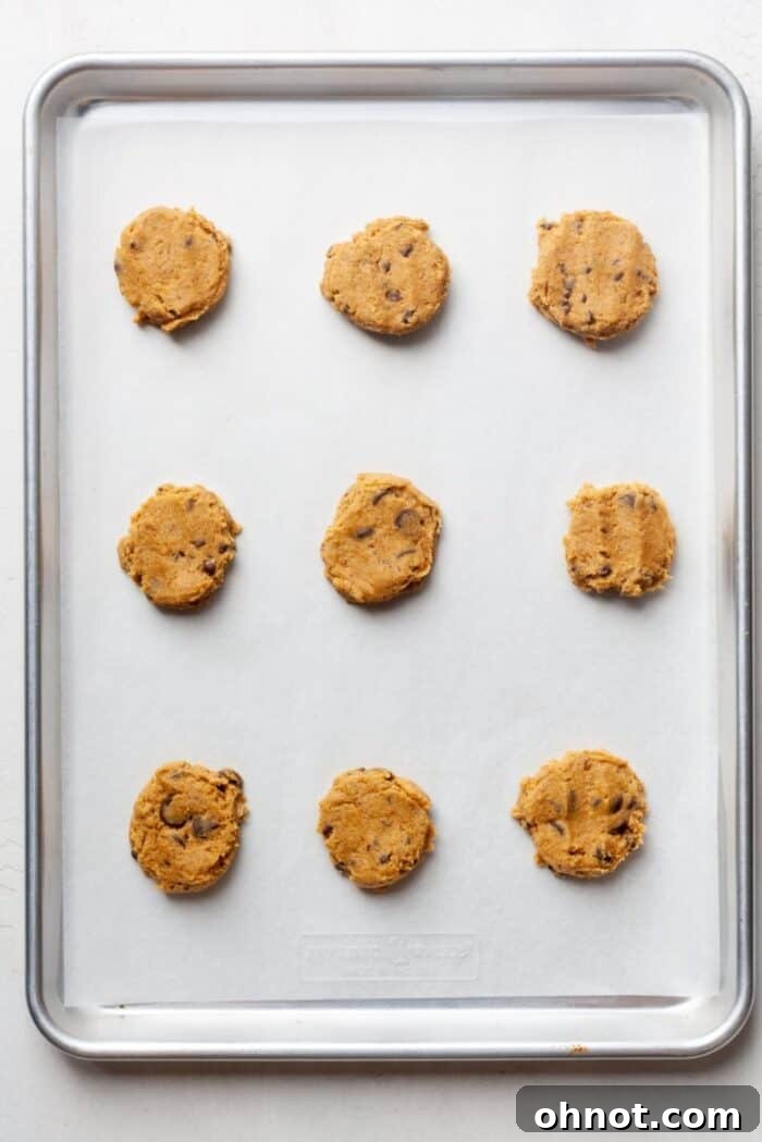 Vegan cookie dough flattened on a baking pan, ready for the oven.