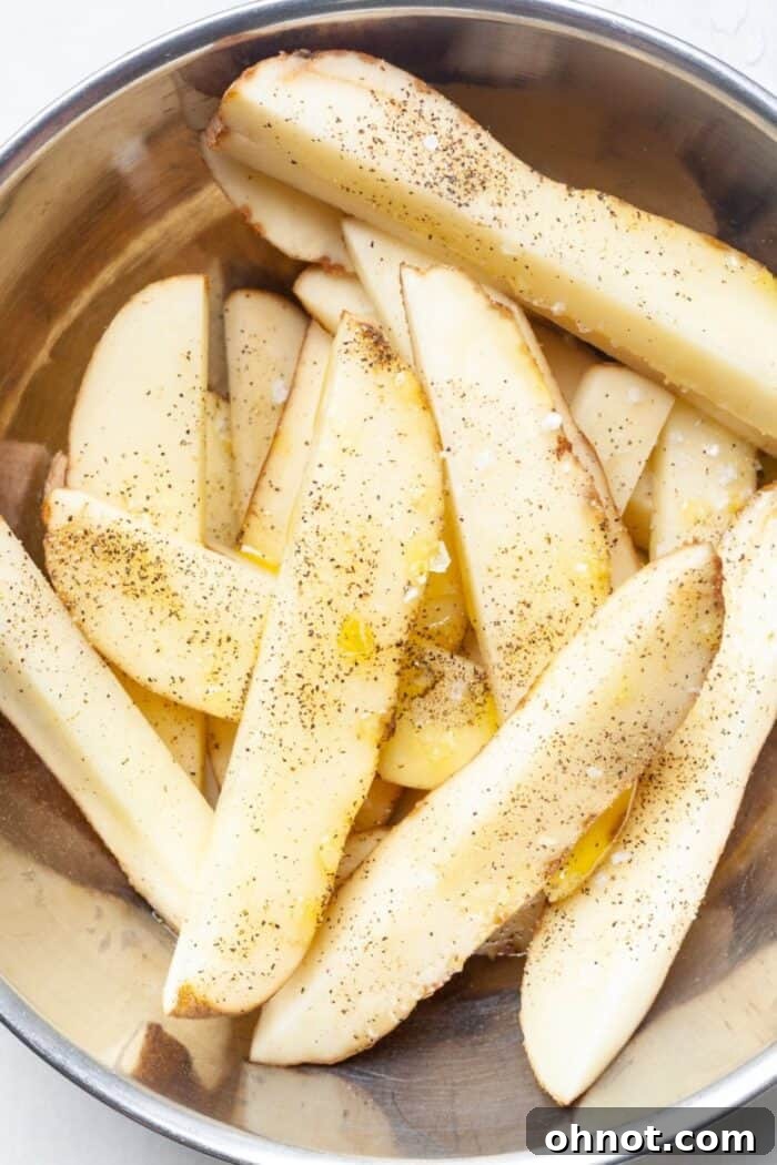 Seasoned homemade fries in a bowl ready for baking