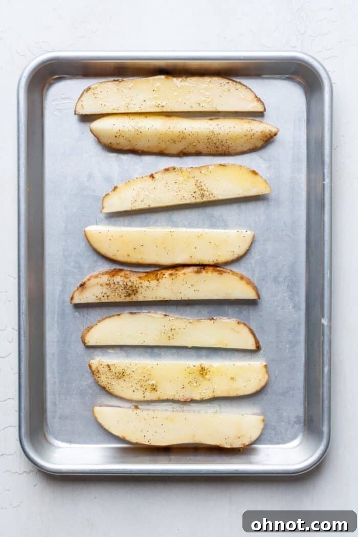 Oven baked fries spread on a baking pan in a single layer