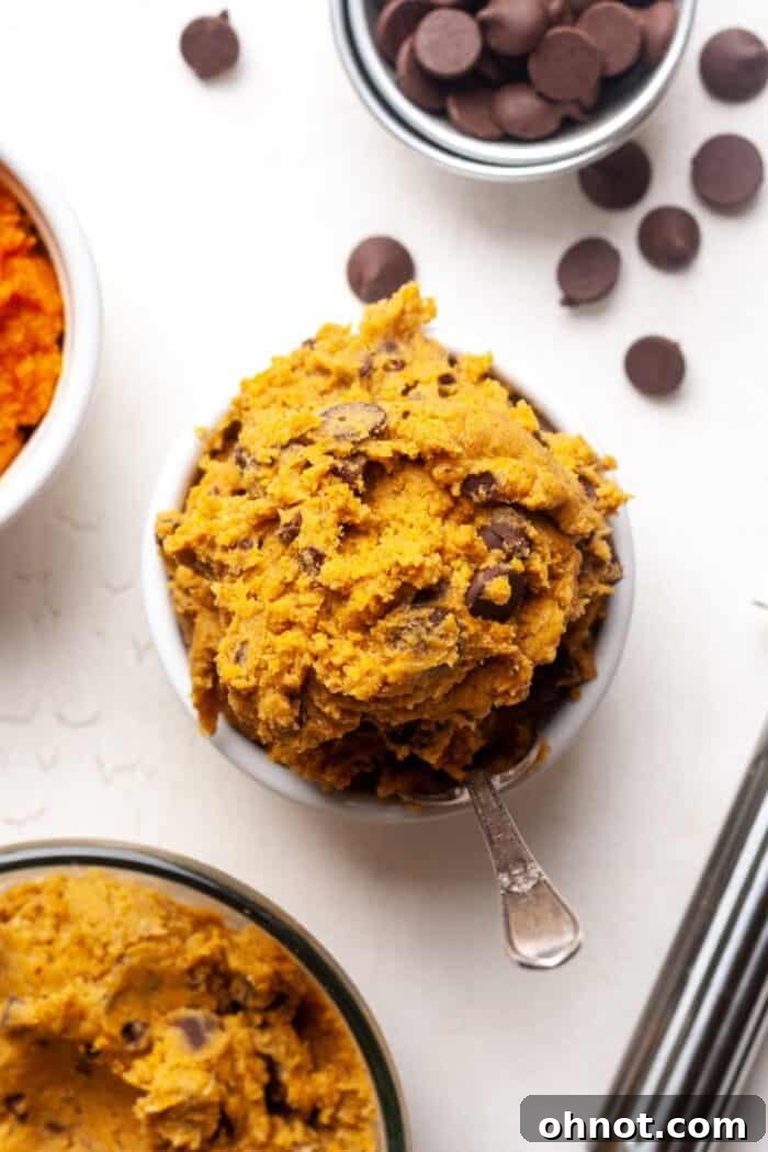 Close-up of creamy edible pumpkin cookie dough in a bowl, showing its rich texture and chocolate chips.