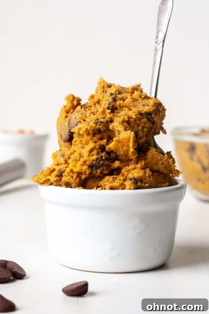 Vegan cookie dough in bowl with spoon, highlighting its creamy texture.