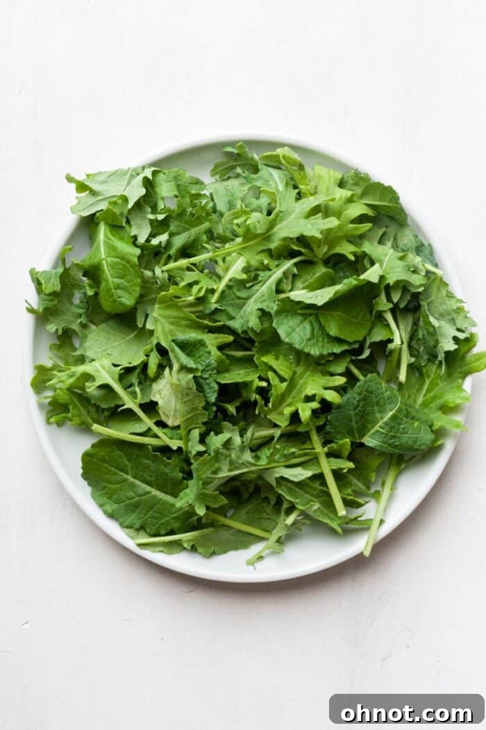A plate with a generous portion of fresh baby kale, ready to be topped with the taco salad ingredients.