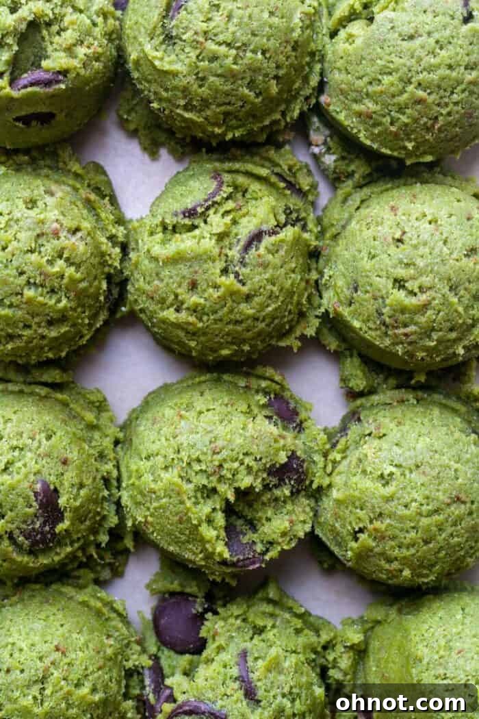 Scoops of vibrant green matcha cookie dough dotted with chocolate chips