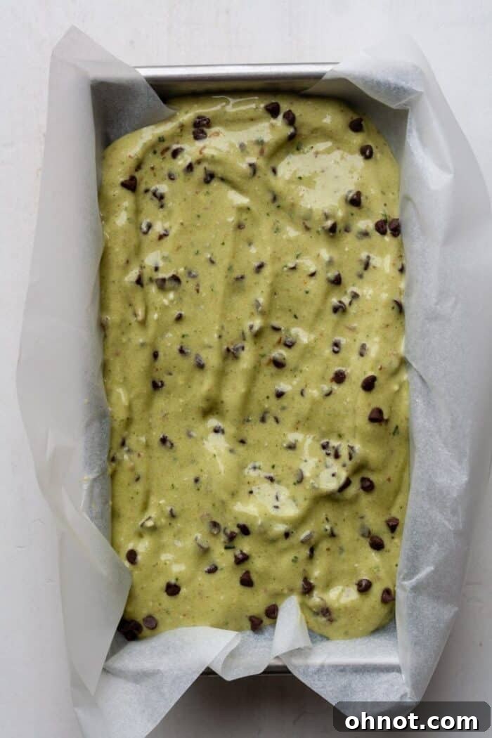 Green nice cream poured into a parchment-lined bread pan