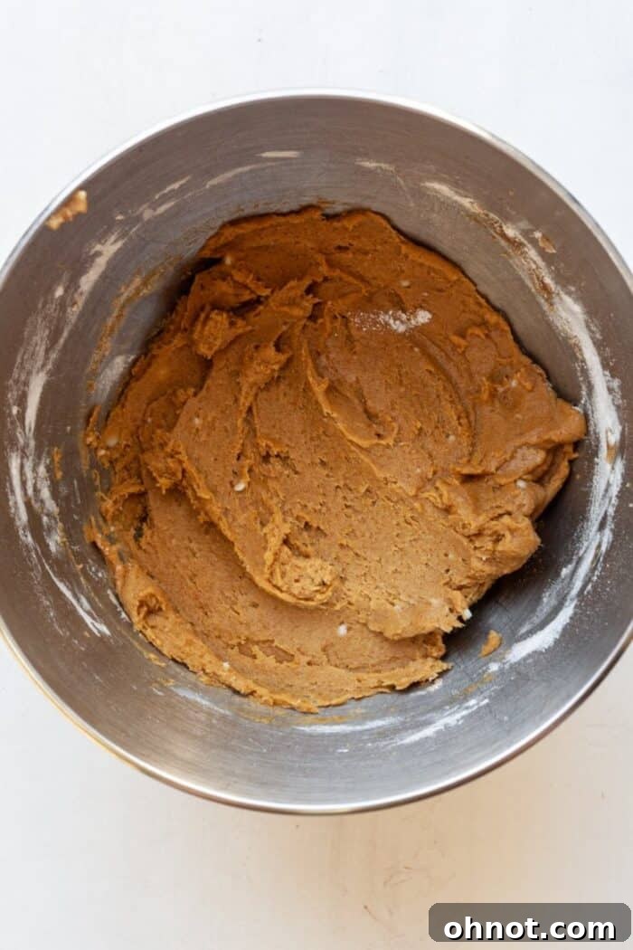 Thick pumpkin cookie dough in a mixing bowl, before adding chocolate chips.