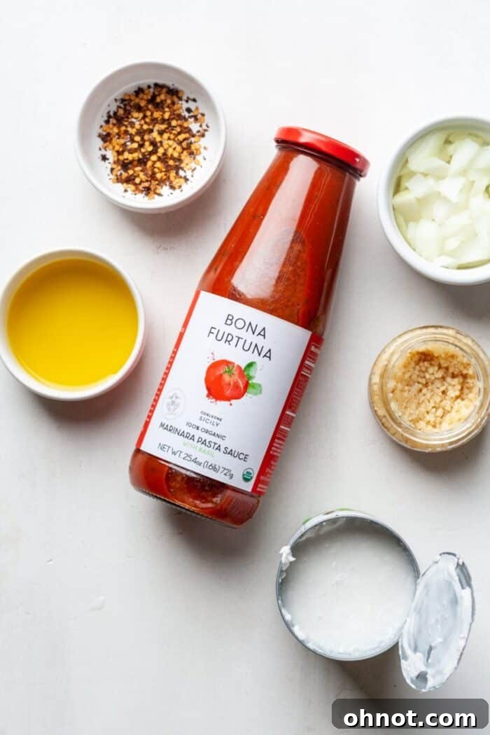 Ingredients for creamy tomato sauce laid out on a table