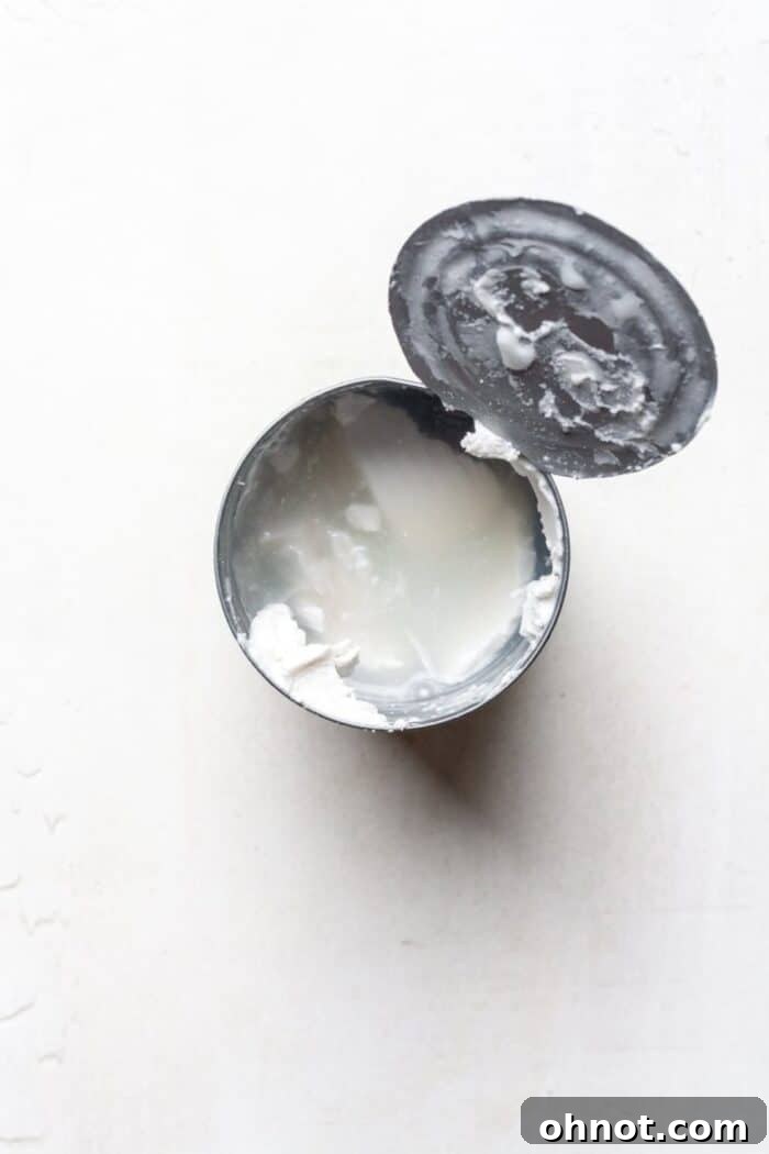 Canned coconut milk before stirring, showing separation of cream and water
