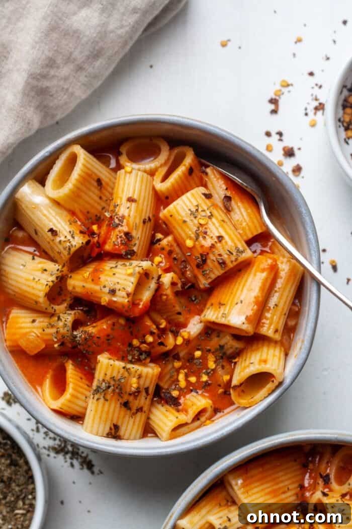 Close-up of pasta with creamy coconut milk sauce, garnished with fresh herbs