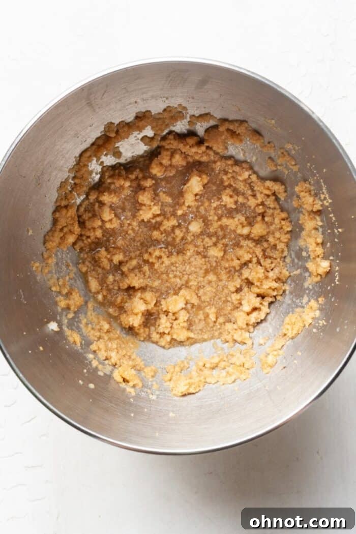 Raw cookie batter in a bowl, after combining almond milk, vanilla extract, and applesauce.